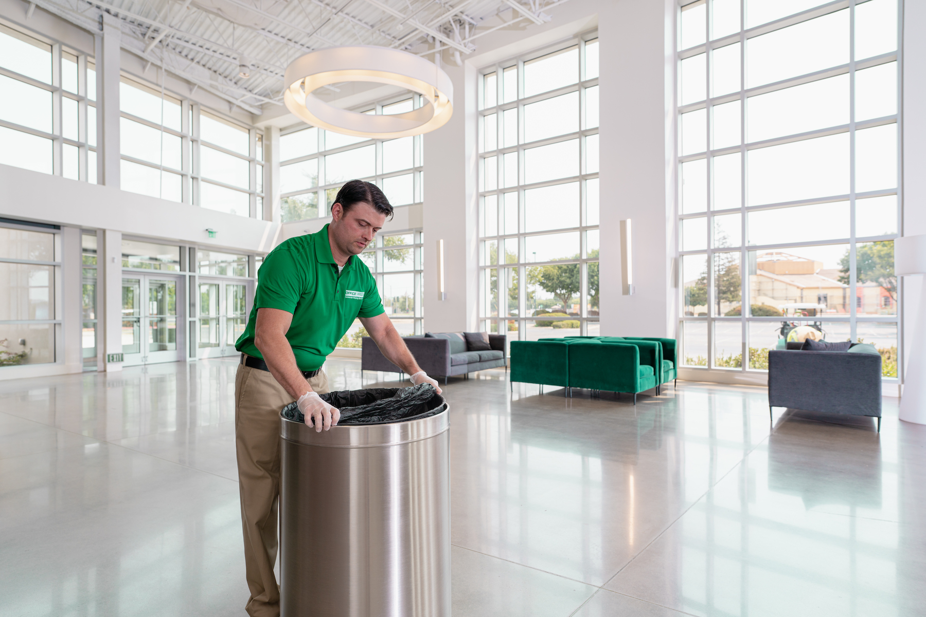 Office Pride commercial cleaning professional servicing a modern lobby and waiting area